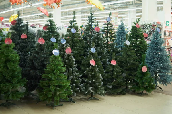 Mağazada çeşitli yapay Noel ağaçları satıyorum.