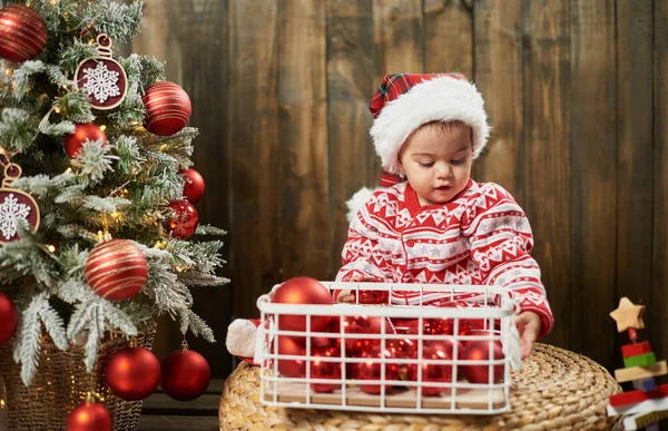 Маленька дівчинка і різдвяні прикраси в кошику. — стокове фото