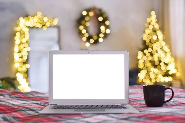 Laptop mit leerem Bildschirm im gemütlichen Weihnachtsinterieur lizenzfreie Stockfotos