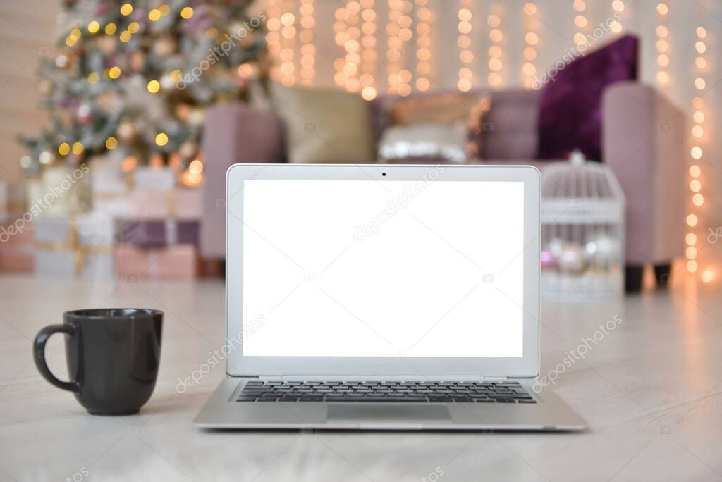 Laptop with white blank screen on the background of the Christmas interior