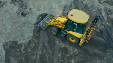 STARIY OSKOL, RUSSIA - 2 Aralık 2020: Bir JCB kazıcısının hava görüntüsü manzarayı düzleştiriyor