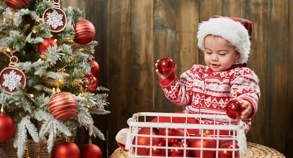 Біла кавказька дитина дістає різдвяні прикраси з кошика. — стокове фото
