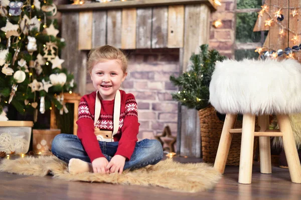Щаслива дитина сидить на підлозі поруч з різдвяним декором — стокове фото