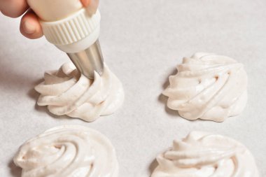 Şef krema yapmak için şırıngadan krema sıkar.