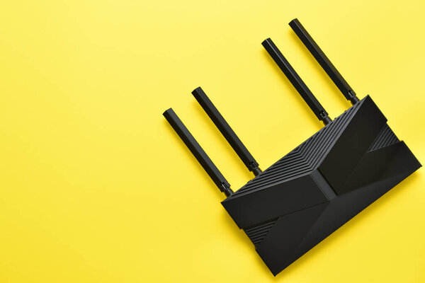 Современный черный Wi-Fi маршрутизатор на желтом фоне с копировальным пространством