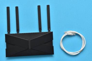 Mavi arkaplandaki bağlantı için modern wi-fi yönlendirici ve ethernet kablosu