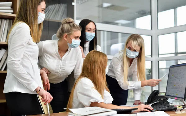 Bürokauffrau in Schutzmasken bei Besprechung im modernen Büro Stockbild