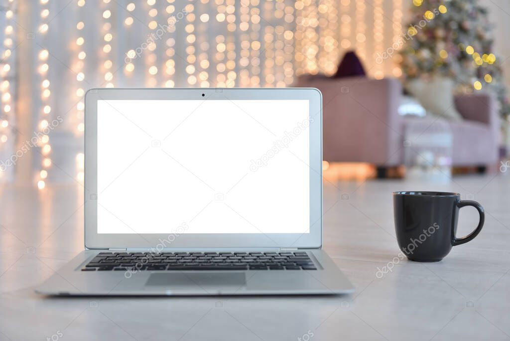 Laptop mockup with white blank screen on background of Christmas interior