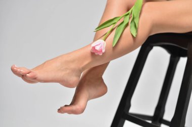 Kadın bacakları tüy dökümü ve lale çiçeği, vücut bakımı ve kadınlık kavramı