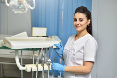 Diş tedavisi için çalışan genç bir dişçinin portresi