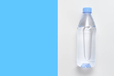 Beyaz ve mavi arka planda su bulunan plastik şişe.