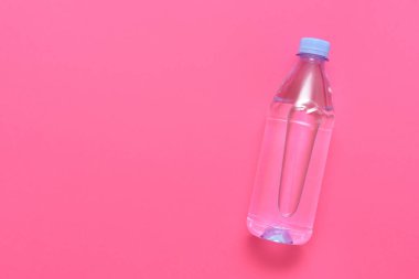 Pembe arka planda su olan plastik şişe.