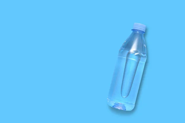 Garrafa de plástico com água em um fundo azul — Fotografia de Stock