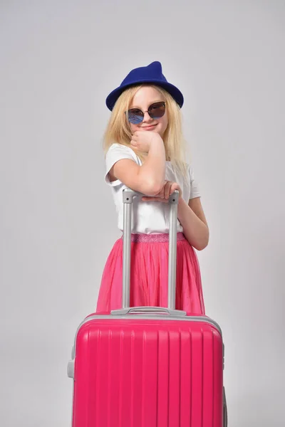 Κορίτσι παιδί έτοιμο να ταξιδέψει και να ποζάρει με μια ροζ βαλίτσα — Φωτογραφία Αρχείου