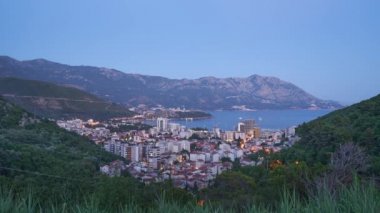 Akşamın gelişi ve Budva şehrinin ışıkları zaman aşımı.
