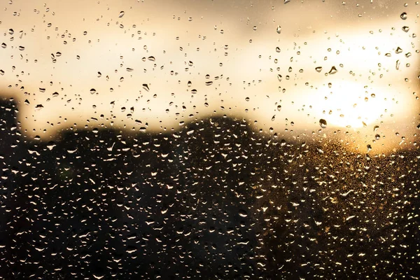 raindrops on the window glass, sunset, evening in the city