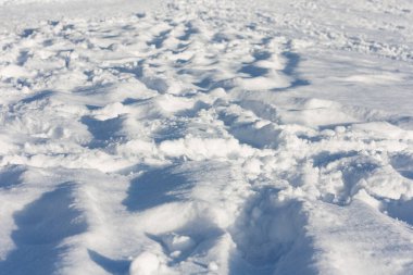 Şehir parkında ayak izleri olan kar, dondurucu güneşli bir günde kış konsepti