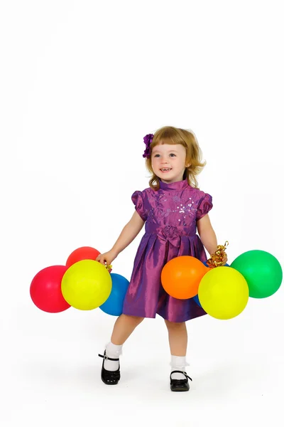 Smiling young girl with balloons in their hands in a purple dres — Stock Photo, Image
