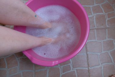 Pedikür prosedürü 1 'den önce kasedeki kadın ayaklarını yıkıyor.