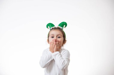 Kafasında elf şapkası şeklinde bir çember olan kız hava öpücüğü yolluyor. Noel konsepti.