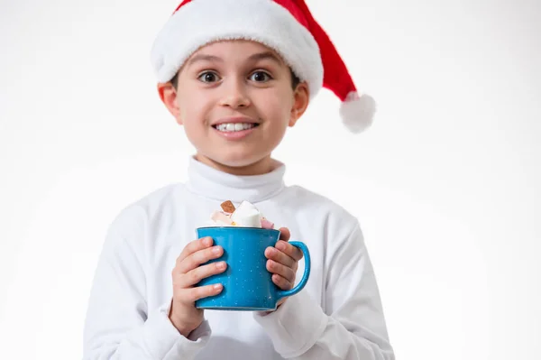 Der Junge Mit Dem Roten Weihnachtsmann Hut Lächelt Und Hält — Stockfoto