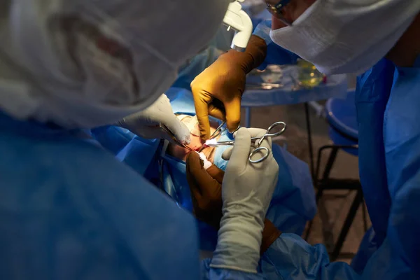 Surgery. Top view of ?perating wound. Hands of surgeons with tools. Medical intervention.