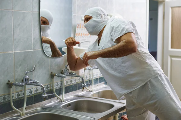 一位外科医生洗手后用肘部关掉水龙头 手术前的手部治疗 — 图库照片