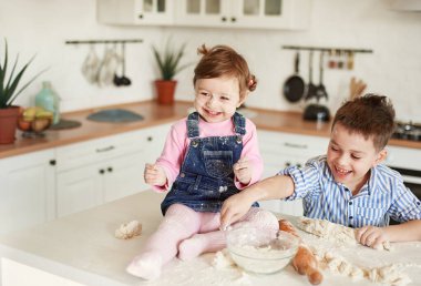 Çocuklar gülüyor, yüzleri ve kıyafetleri un içinde.