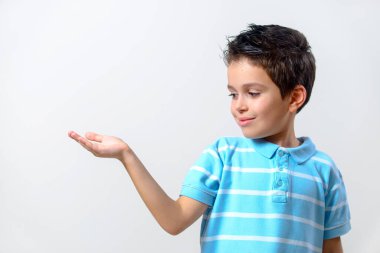 Mavi tişörtlü çocuk avucunu önünde açık tutuyor..