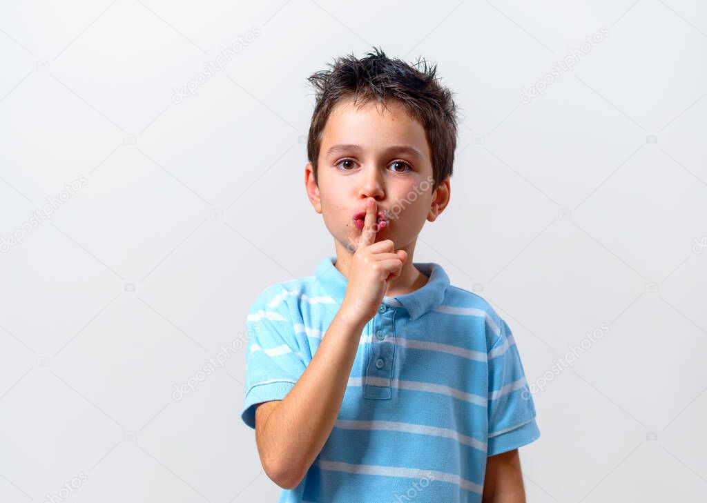 The boy in a blue T-shirt calls for a gesture to shut up. Keep quiet.