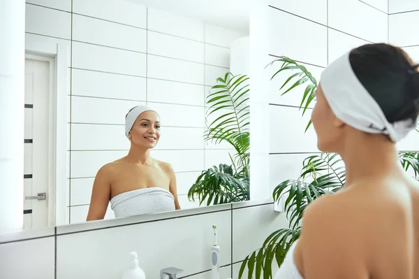 Banyoda Dikilirken Aynadaki Yansımasına Gülümseyen Genç Kadın — Stok fotoğraf