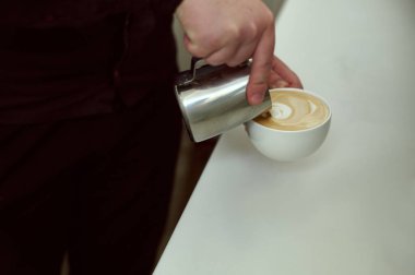 Barista latte yapıyor. Kahve ve süte odaklan..