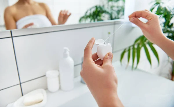 Elinde diş ipi tutan kadınların ellerine odaklan.