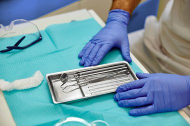 Diş hekimliği ve dişçi aletleri mavi arkaplanı kapatıyor. Yakın görünüm