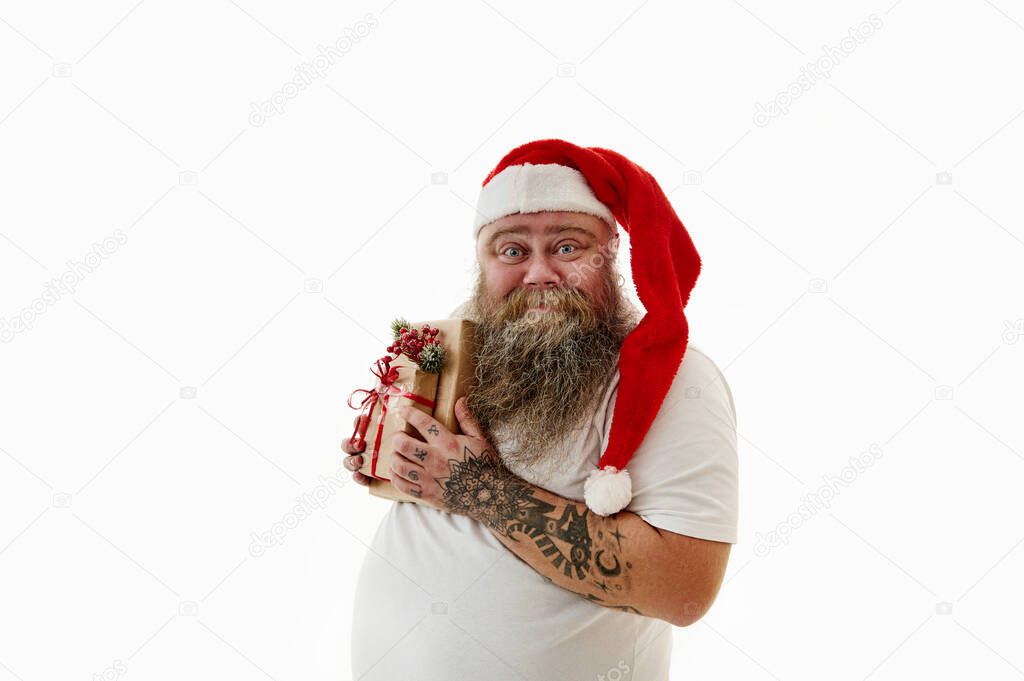 Happy man tightly hugs a New Year's gift. Isolated portrait
