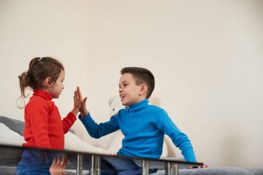 İki mutlu çocuk el çırpıyor. Erkek ve kız kardeş çocukluğun tadını çıkarıyor