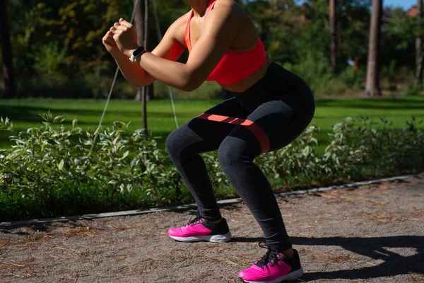 Athletic Woman Exercising Elastic Fitness Band While Being Squat Position — Stock Photo, Image