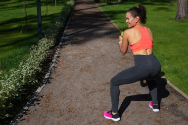 Spor giyim kuşamında spor yapan genç ve güzel bir kadının yan görüntüsü.