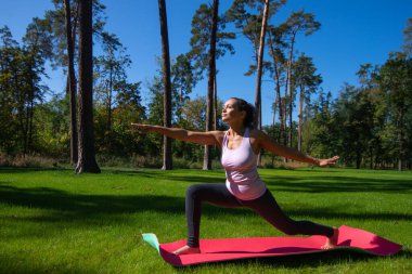 Dışarıda yoga yapan bir kadın. Rahatlamak, asana, dışarıda spor yapmak.
