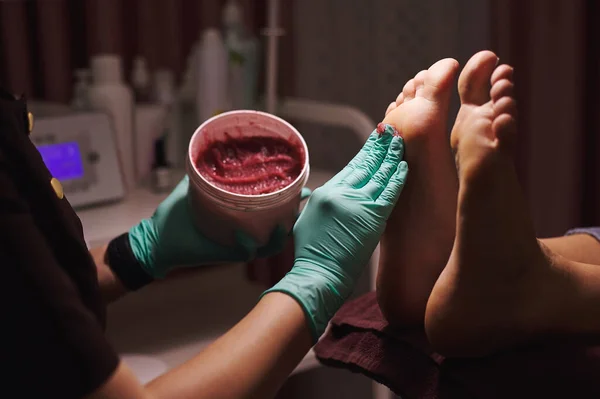 Closeup of foot massage with a foot scrub during a professional pedicure in beauty salon