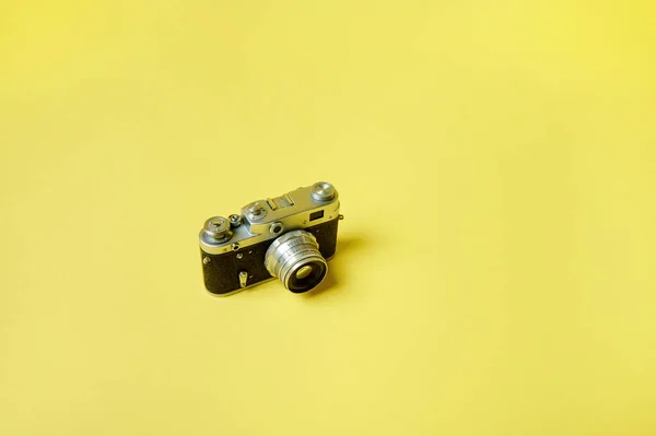 Top view of an old model film camera isolated on a yellow background