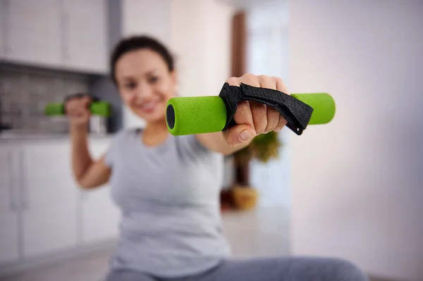 家で運動するスポーティーな女性の手に小さな緑のダンベルに焦点を当てる — ストック写真