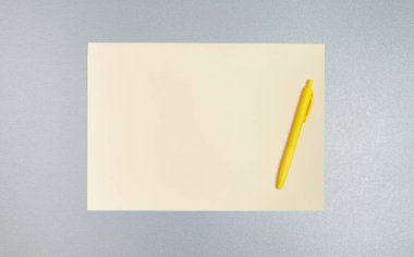 Üst manzara, kopyalama alanı, düz sarı kalem ve kağıt kaplama gri bir yüzey. Ofis kavramı