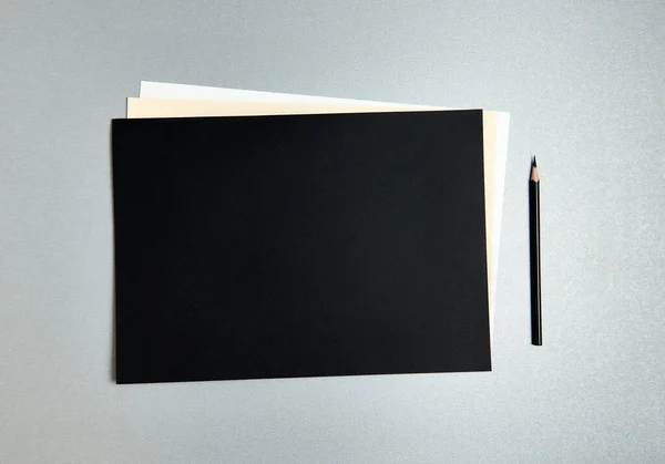 Czarny Ołówek Obok Designerskiego Papieru Różnych Kolorach Szarym Tle — Zdjęcie stockowe