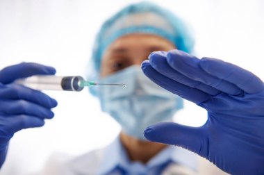 Beyaz arka planda izole edilmiş nüfusu aşılamaya hazır bir şırıngayla doktor. Aşı günü. Bulaşıcı Hastalıklarla Mücadele.