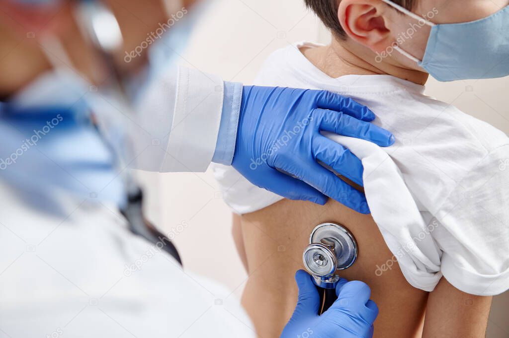 Close up of pediatrician using stethoscope, checking up heartbeat and lungs while auscultation in doctor office at hospital.