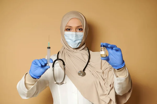 Μουσουλμάνος Γιατρός Καλυμμένη Σύριγγα Για Κεφάλι Και Εμβόλιο Και Κοιτάζοντας Royalty Free Εικόνες Αρχείου