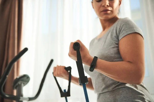Close-up woman exercising with a harness for fitness, doing exercises on the muscles of the arms