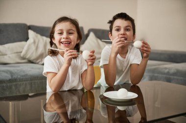 İki sevimli çocuk ellerinde yumurta ve fırçalarla Paskalya yumurtalarını süslemeye hazırlar. Paskalya konsepti