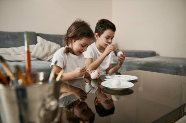 Evde Paskalya yumurtası süsleyen iki sevimli çocuk. Geleneksel dini etkinlik.